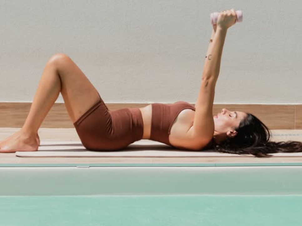 Luisa Balestrino si allena con un manubrio rosa a bordo piscina